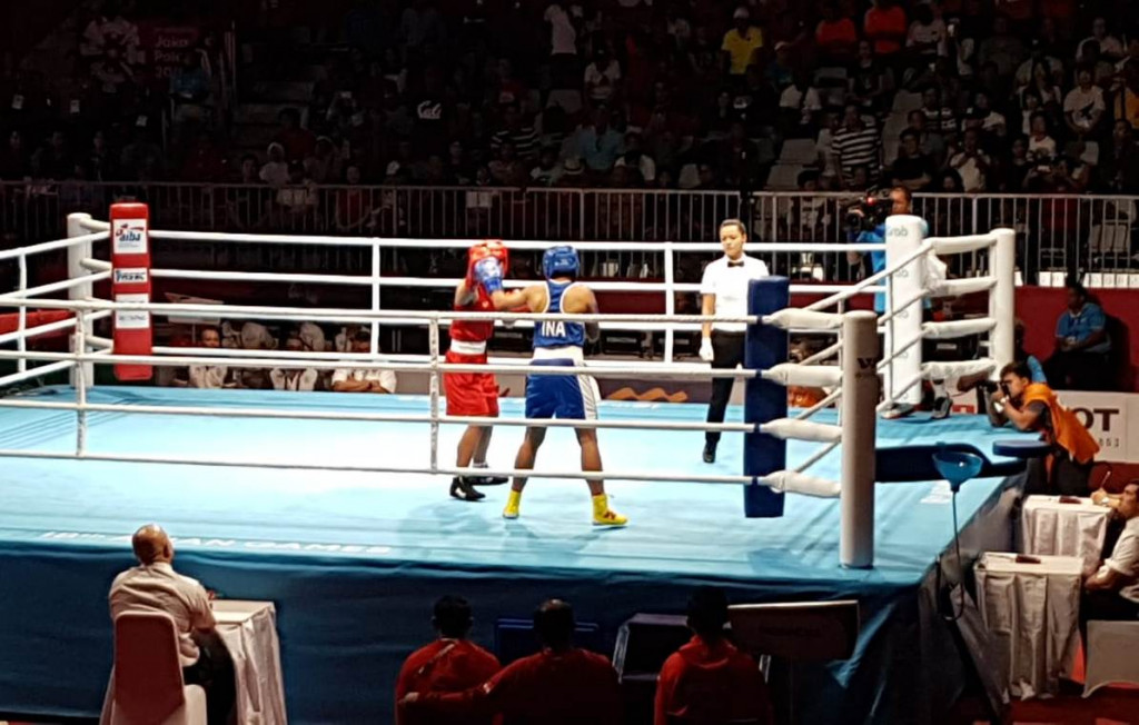 Petinju putri Indonesia (biru) saat meladeni perlawanan atlet Thailand di babak semifinal kelas ringan putri Asian Games 2018 (Foto: medcom.id/M. Rizky Adhestian)
