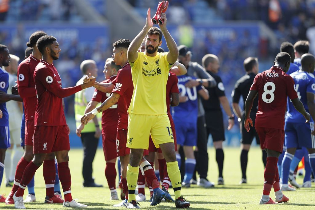 Kiper Liverpool Allison Becker, merayakan kemenangan timnya atas Leicester City. (Photo by Adrian DENNIS / AFP)
