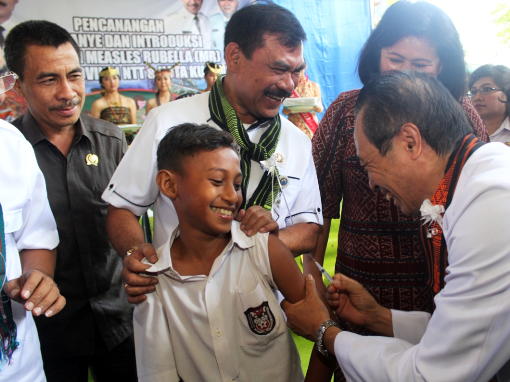 Dokter Anak Frans Taolin menyuntikan vaksin Measles (campak) Rubella (MR) ke siswa Sekolah Dasar (SD) Santa Theresia Kupang, Nusa Tenggara Timur, Rabu (1/8). Foto: MI/Palce Amalo.