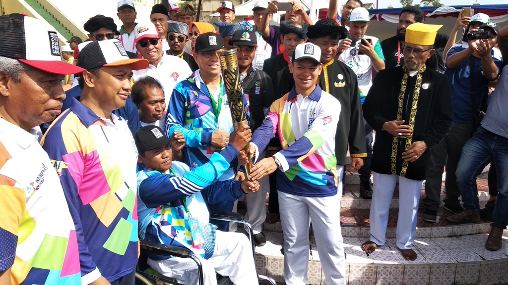 Ketua INAPGOC Raja Sapta Oktohari menyerahkan obor Asian Para Games 2018 kepada atlet disabitas Risal Assor. (Foto: Medcom.id/Rendy)