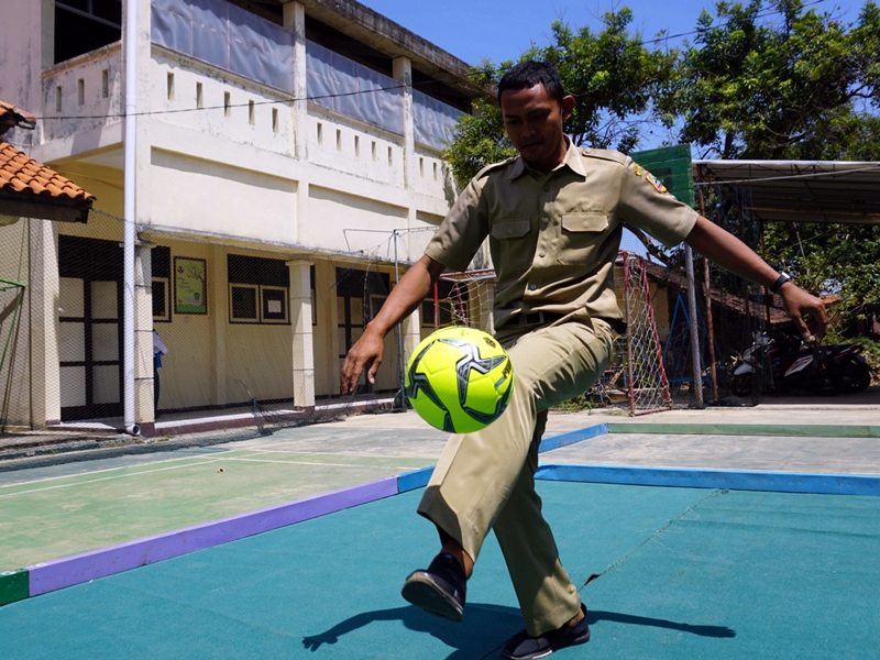 Pradono Desiriyanto bermain bola di halaman belakang SLB Negeri Jepara. Medcom.id/Rhobi Shani