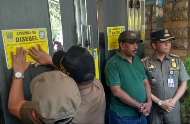 Petugas Satpol PP menyegel salah satu Tempat Hiburan Malam (THM) di wilayah Cikarang Selatan, Kabupaten Bekasi, Selasa, 9 Oktober 2018. Medcom.id/ Antonio.