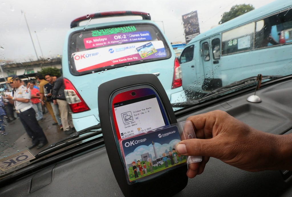 Penumpang melakukan tab menggunakan kartu OK Trip (One Karcis One Trip) di Terminal Kampung Melayu, Jakarta Timur. Foto: MI/Ramdani