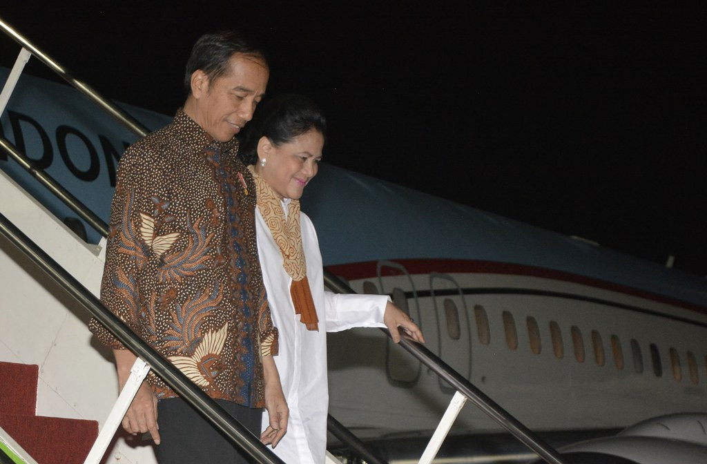 Presiden Joko Widodo (kiri) didampingi Ibu Negara Iriana Joko Widodo (kanan) berjalan menuruni tangga pesawat kepresidenan setibanya di Bandara Internasional I Gusti Ngurah Rai, Bali (ANTARA FOTO/Fikri Yusuf)