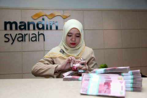 Petugas menghitung uang di Bank Syariah Mandiri, MI/Panca