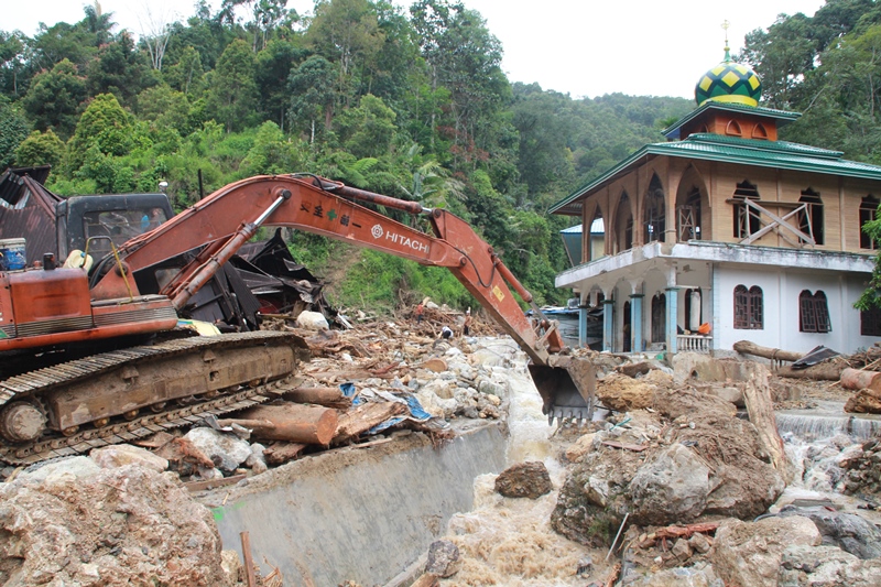 Petugas menggunakan alat berat berusaha menggeser batu yang terbawa arus sungai pascabanjir bandang yang terjadi, di Desa Muara Saladi, Kecamatan Ulu Pungkut, Mandailing Natal, Sumatera Utara, Sabtu (13/10). ANTARA FOTO/Holik Mandailing.