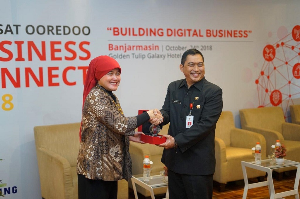 Group Head Regional Account Indosat Ooredoo, Fuli Humairoh (kiri) berjabat tangan dengan Asisten Bidang Perekonomian dan Pembangunan Sekretariat Daerah Provinsi Kalimantan Selatan, Hermansyah Manaf (kanan). 