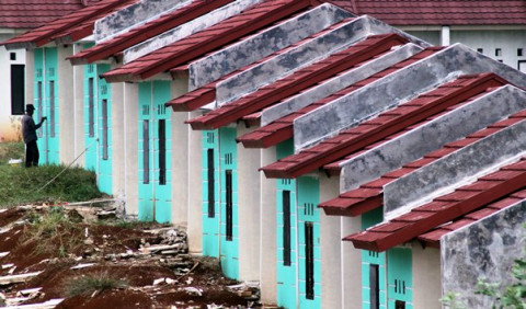 Pekerja sedang mengecat dinding luar rumah-rumah murah di Bojong