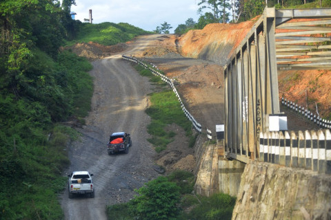 Kendaraan melintasi ruas jalan trans Papua Barat yang melintasi
