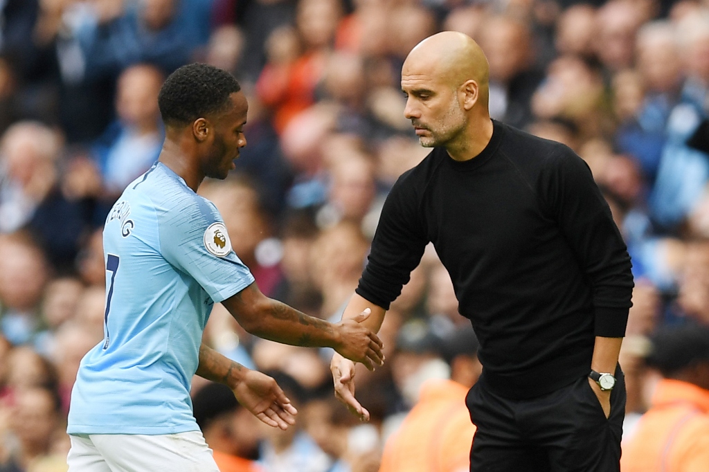 Pep Guardiola berjabat tangan dengan Raheem Sterling (AFP/PAUL ELLIS)