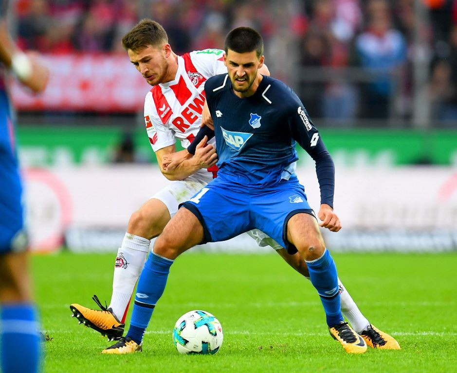 Gelandang Hoffenheim, Florian Grillitsch, mencoba menjaga bola dari gelandang Koln, Salih Ozcan (AFP/Patrik Stollarz)