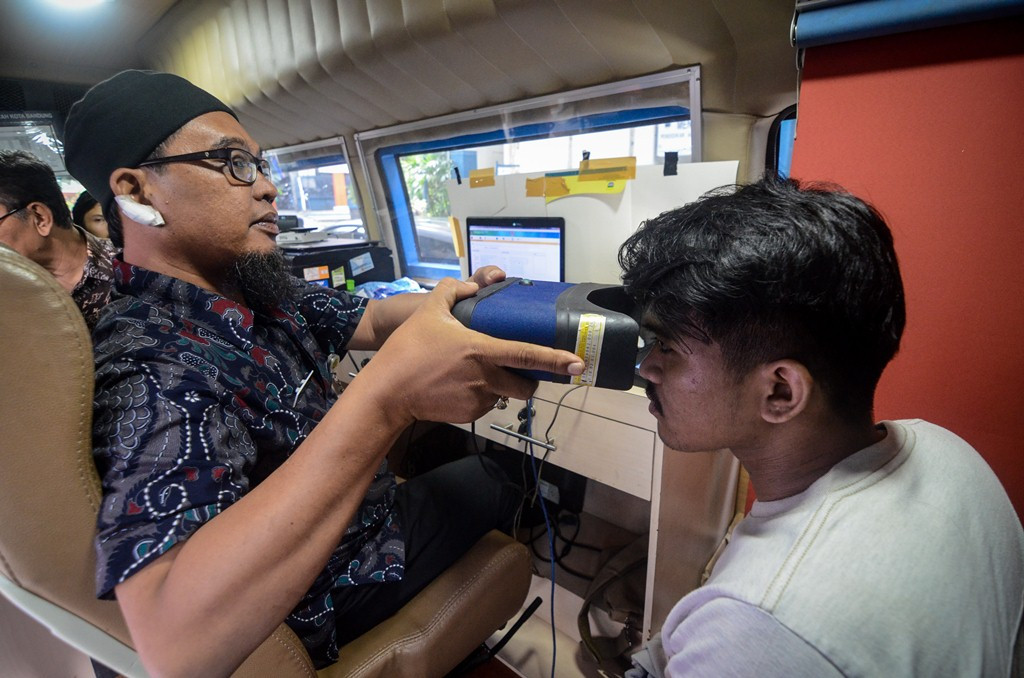 Petugas Disdukcapil Kota Bandung merekam KTP elektronik di Kampus Universitas Islam Bandung, Bandung, Jawa Barat, Kamis (27/12/2018). Foto: Antara/Raisan Al Farisi