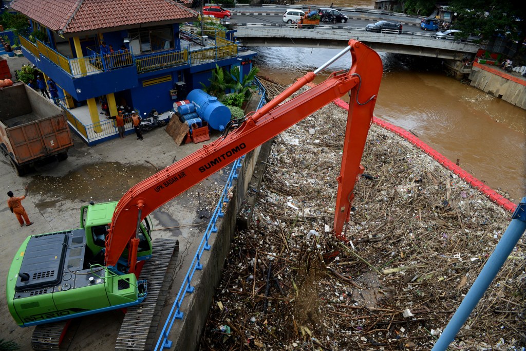 Ekskavator mengangkut sampah kiriman yang menumpuk di Pintu Air Manggarai, Jakarta Selatan. Foto: MI/Susanto.