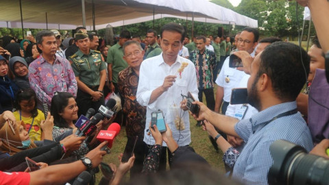 Presiden Joko Widodo memegang jajanan yang dibeli di Lapangan