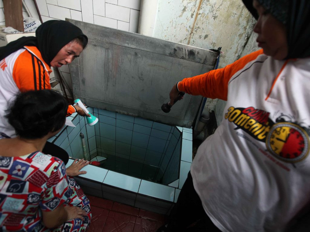 Petugas memeriksa bak penampungan air dirumah salah satu warga saat program pemberantasan sarang nyamuk (PSN). Foto: MI/Ramdani.
