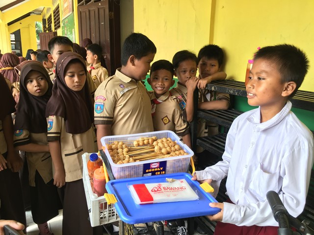 Muhamad Saputra, 12, pelajar kelas 3 SDN 01 Jurang Mangu Timur, Kecamatan Pondok Aren, Kota Tangerang Selatan berjualan di depan kelasnya, Rabu, 13 Februari 2019. Medcom.id/ Farhan Dwitama.
