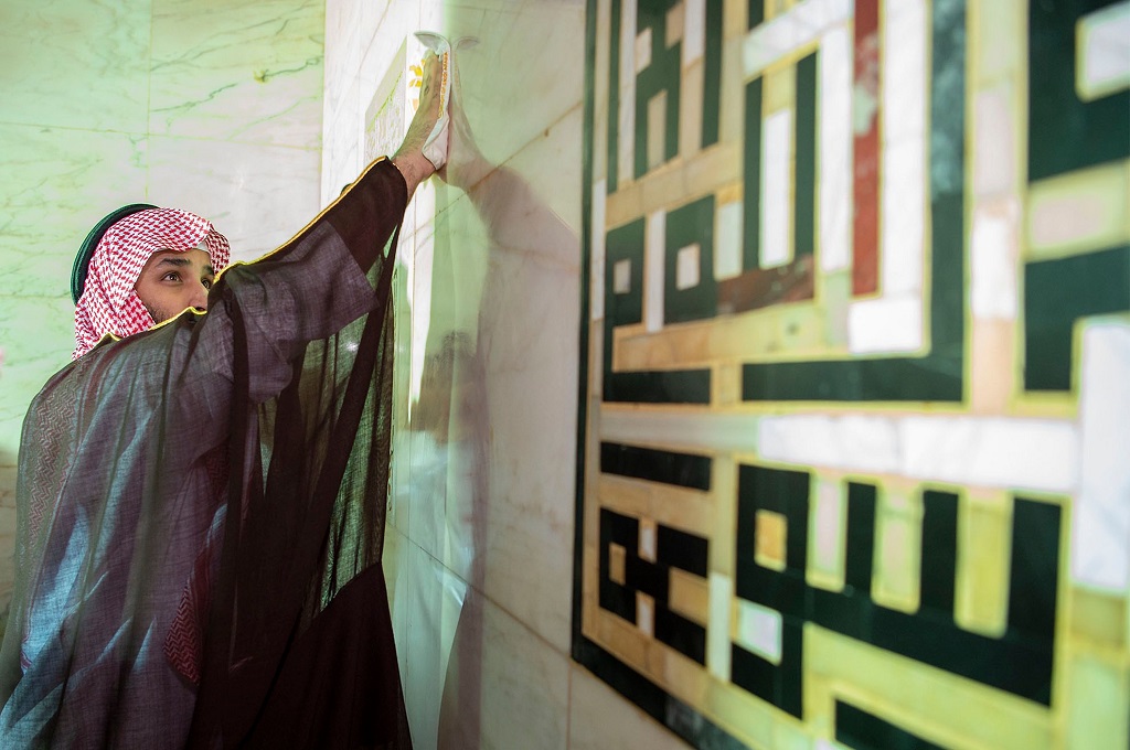 Putra Mahkota Arab Saudi Pangeran Mohammed bin Salman menyeka dinding di Masjid Agung di Makkah, 12 Februari 2019. (Foto: AFP/Saudi Royal Palace/BANDAR AL-JALOUD)