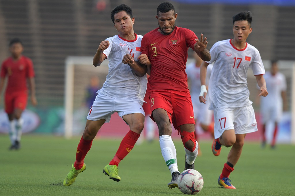 Marinus Wanewar sedang diapit dua pemain Vietnam. (ANTARA FOTO/Nyoman Budhiana)