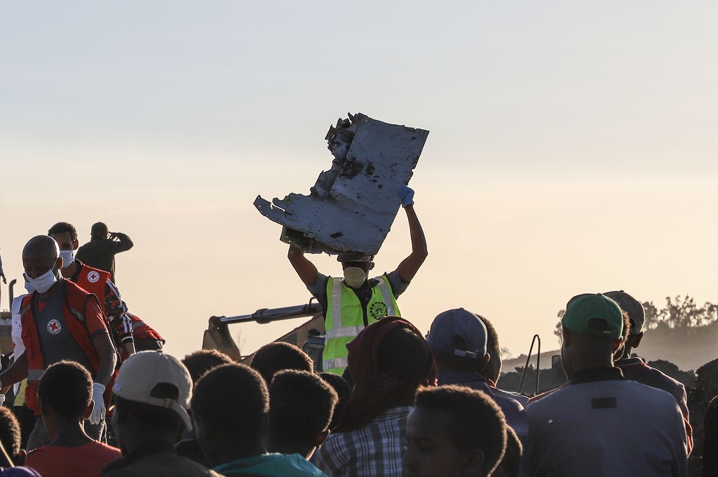 Petugas mengangkat sebuah serpihan di lokasi kecelakaan pesawat maskapai Ethiopian Airlines di dekat kota Bishoftu, Ethiopia, 10 Maret 2019. (Foto: AFP/MICHAEL TEWELDE)