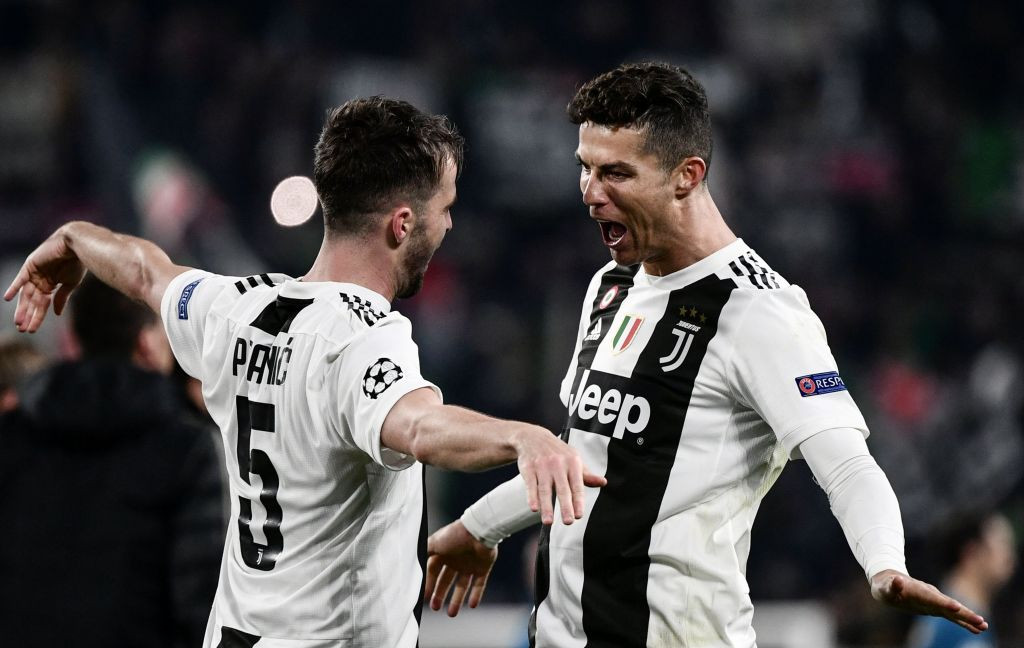 Momen saat Cristiano Ronaldo (kanan) berselebrasi bersama rekan setimnya di Juventus, Miralem Pjanic (kiri) usai membobol gawang Atletico Madrid (Foto: AFP/Marco Bertorello)