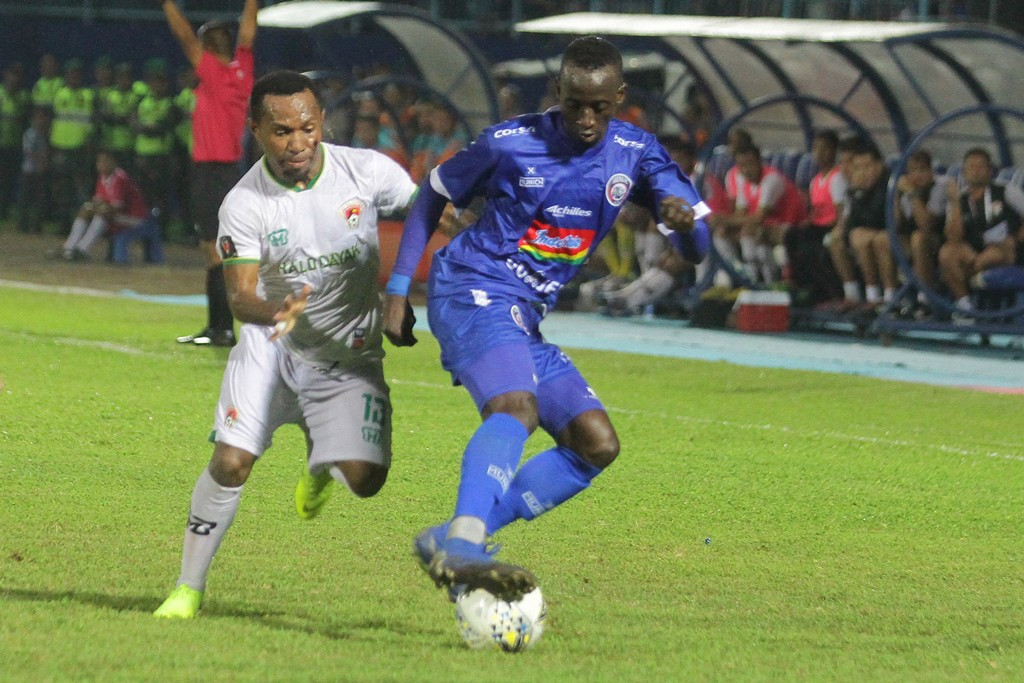  Pesepak bola Arema FC Makan Konate (kanan) berusaha mempertahankan bola dari hadangan pesepak bola Kalteng Putra, Yohanes Ferdinand Pahabol (kiri). (ANTARA FOTO/Ari Bowo Sucipto)