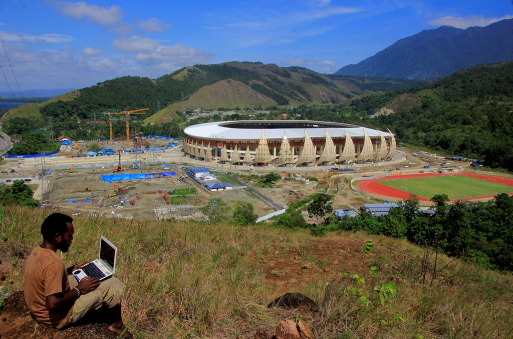 Warga menyaksikan proses pembangunan Kompleks Stadion Papua Bangkit di Distrik Sentani Timur, Kabupaten Jayapura, Papua. (ANTARA FOTO/Gusti Tanati)