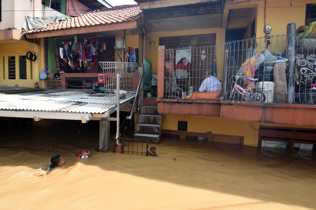 Warga bertahan di rumahnya saat banjir melanda kawasan Rawajati, Jakarta Selatan. (Foto: ANTARA/Indrianto Eko Suwarso)