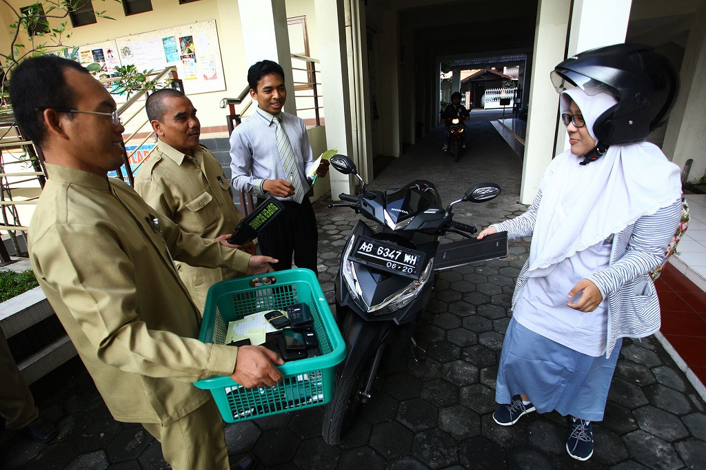 Petugas mengumpulkan telepon genggam dan sabak digital milik pelajar sebelum pelaksanaan Ujian Nasional (UN) di SMA Muhammadiyah 1 Yogyakarta, Andreas Fitri Atmoko.