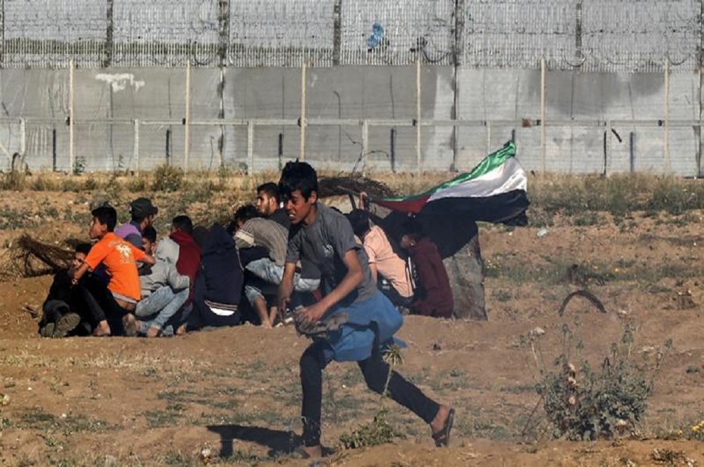 Demonstran muda berlari di sekitar pagar perbatasan Gaza dan Israel pada Jumat 10 Mei 2019. (Foto: Said Khatib/AFP)