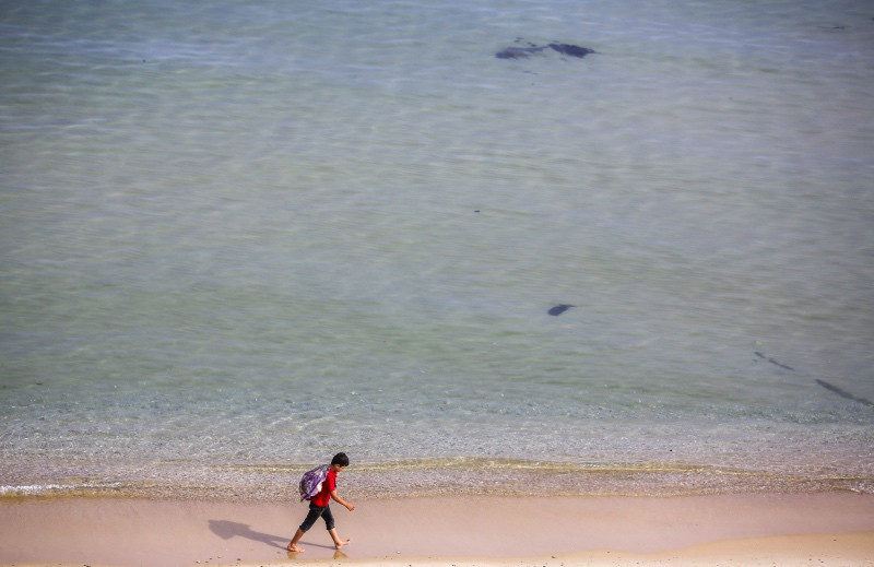 Seorang warga Palestina berjalan di pantai di Gaza. (Foto: AFP).