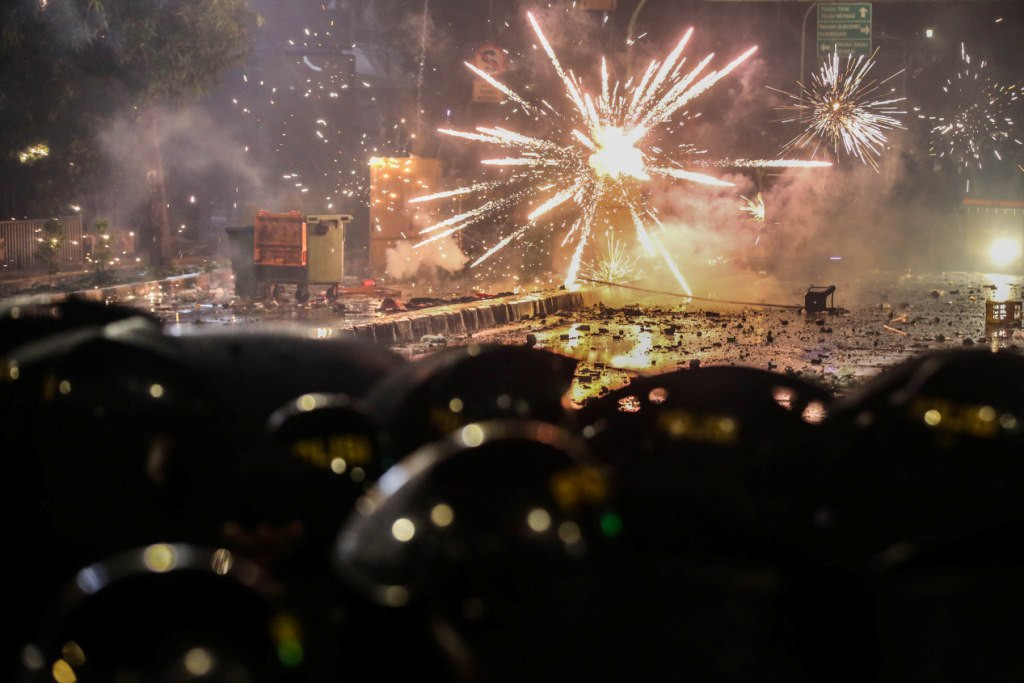 Massa aksi lari berhamburan menghindari gas air mata saat terlibat bentrok dengan polisi di Jalan Wahid Hasyim, depan gedung Bawaslu, Jakarta. Foto: MI/Ramdani.