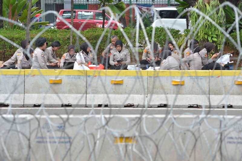 Petugas keamanan bersanatai saat keadaan depan Mahkamah Konstitusi (MK) tidak ada aksi didepan Gedung MK, Jakarta, Senin (24/6). MI/ MOHAMAD IRFAN.