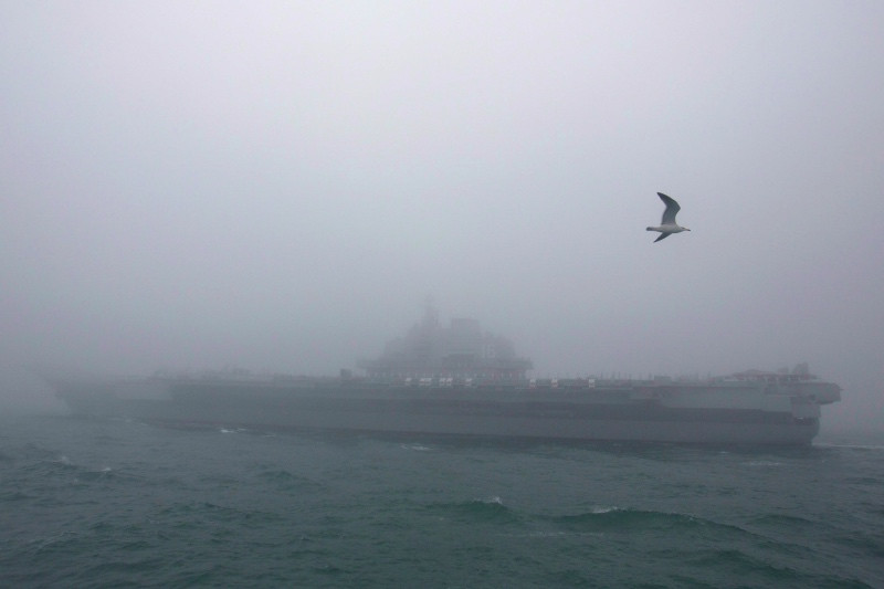Kapal induk milik Tiongkok, Liaoning berlayar tembus kabut di perairan Qingdao. (Foto: AFP).