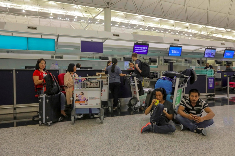Calon penumpang di Bandara Internasional Hong Kong menunggu penerbangan pada 13 Agustus 2019. Foto: AFP.