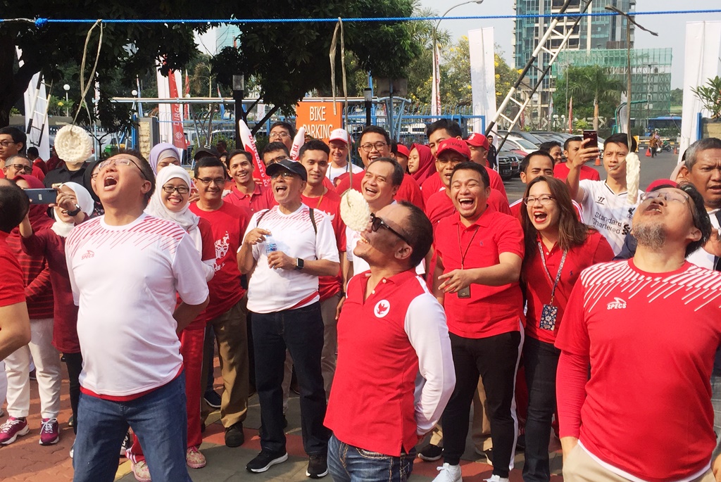 Menaker M Hanif Dhakiri mengikuti lomba makan kerupuk pada acara Pesta Rakyat Tripartit di kantor pusat Kemenaker, Jakarta, Kamis, 15 Agustus 2019 (Foto:Medcom.id/Gervin Nathaniel Purba)
