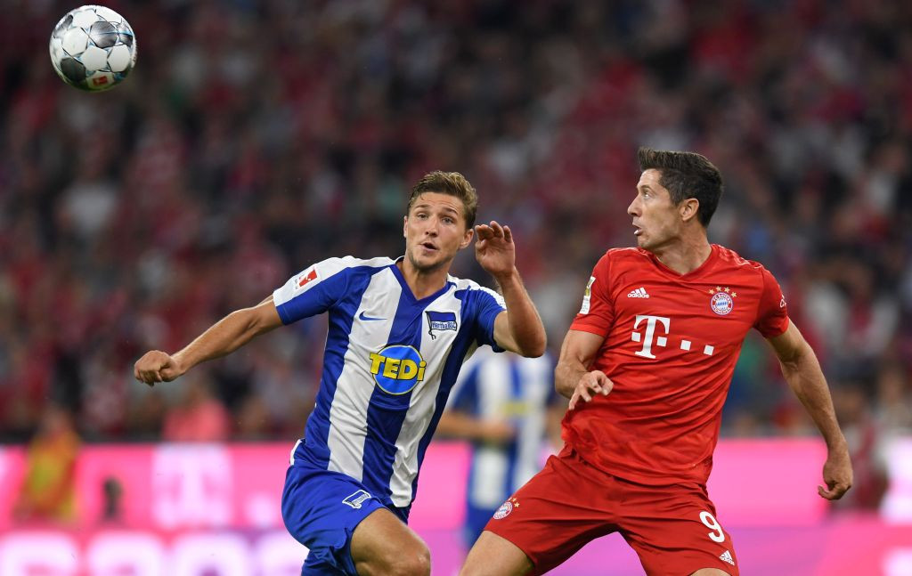 Momen striker Bayern Muenchen Robert Lewandowski (kanan) berduel dengan bek Hertha Berlin Niklas Stark (kiri) di udara (Foto: AFP/Christof Stache)