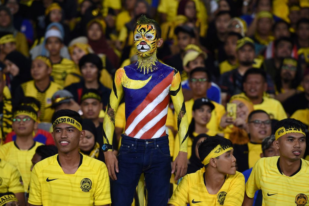 Aksi unik suporter Malaysia saat mendukung tim kesayangannya (Foto: Mohd RASFAN / AFP)