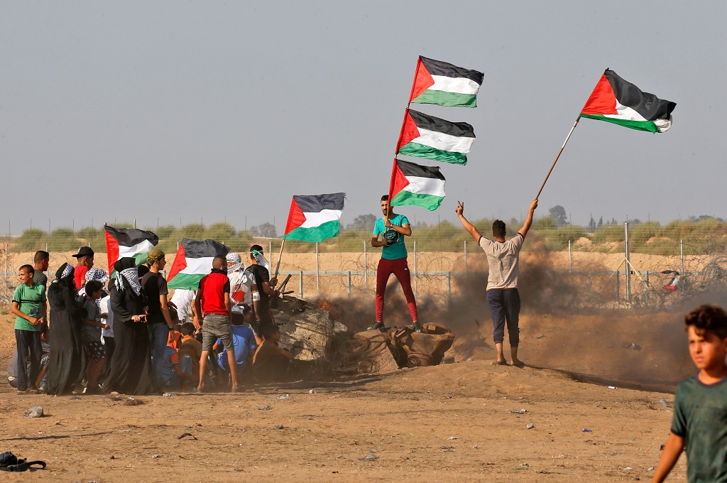 Demonstran mengibarkan bendera Palestina dalam bentrokan dengan pasukan israel di dekat Khan Yunis, Jalur Gaza selatan, 23 Agustus 2019. (Foto: AFP/SAID KHATIB)