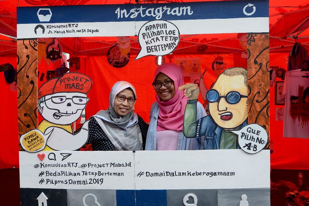 Warga berfoto di booth kreatifitas tentang ajakan pemilu damai di kawasan Cikini, Jakarta. (Foto: MI/Susanto)
