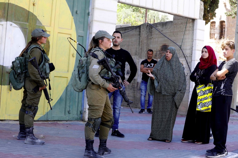 Warga Palestina berhadapan dengan penjagaan pasukan Israel. Foto: AFP