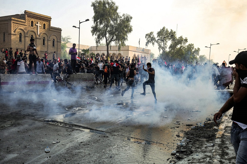 Demonstran berada di tengah kepulan gas air mata dalam bentrok dengan aparat keamanan di Baghdad, Irak, Selasa 1 Oktober 2019. (Foto: AFP/AHMAD AL-RUBAYE)