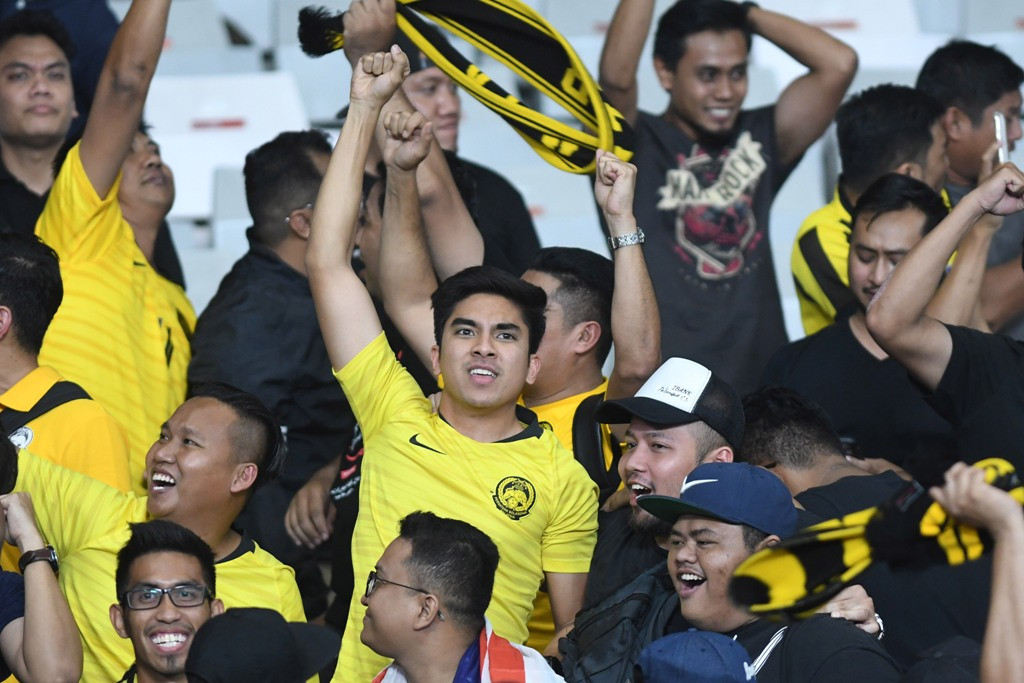Menteri Belia dan Sukan Malaysia Syed Saddiq Abdul Rahman (tengah) memberi dukungan pada timnas Malaysia saat melawan timnas Indonesia. (ANTARA FOTO/M Risyal Hidayat)