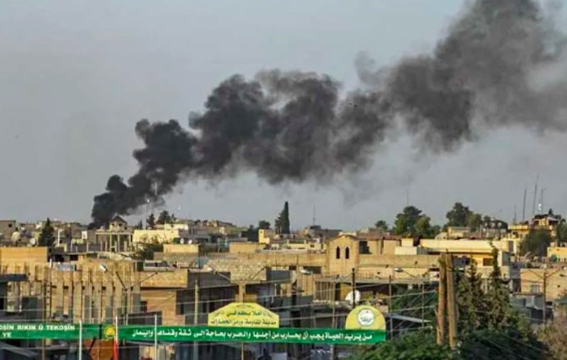 Asap tampak dari Kota Ras al-Ain yang turut diserang oleh Turki. Foto: AFP