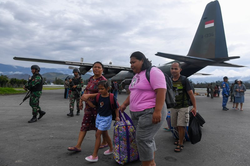 Pengungsi berjalan menuruni pesawat Hercules TNI AU ketika tiba di Bandar Udara Wamena, Kabupaten Jayawijaya, Papua, Kamis (10/10/2019). 