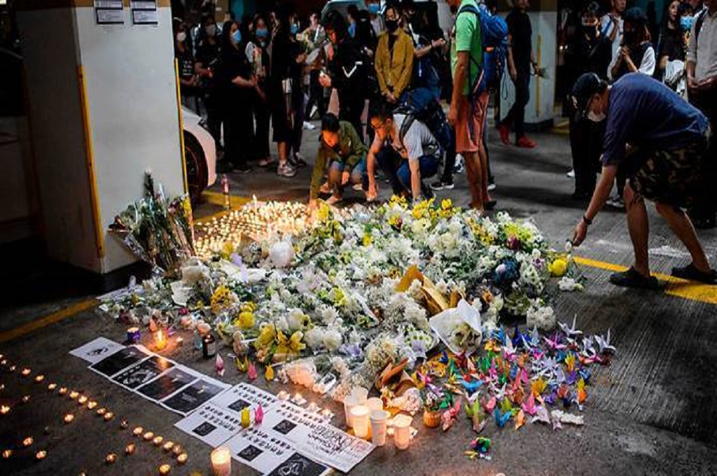 Demonstran pro-demokrasi meletakkan bunga dan menyalakan lilin di tempat tewasnya mahasiswa bernama Alex Chow Tsz-lok, Jumat 8 November 2019. (Foto: AFP / Anthony WALLACE)