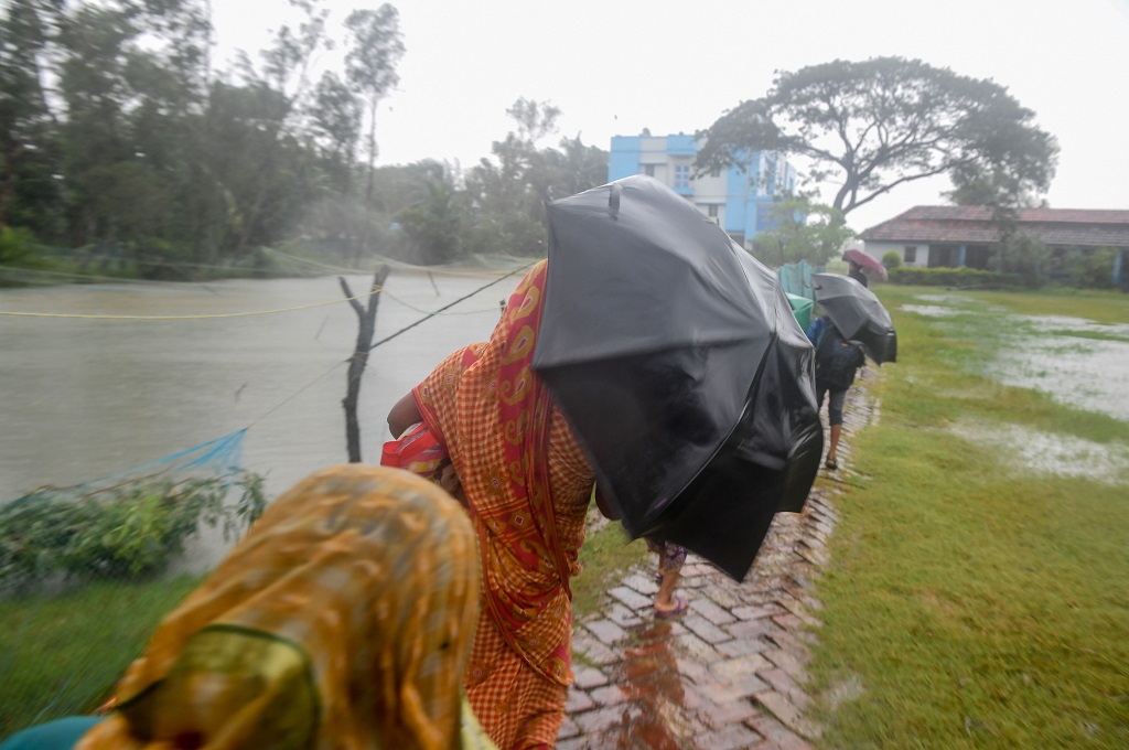 Warga India berusaha memasuki tempat penampungan di tengah terjangan Siklon Bulbul di West Bengal, 9 November 2019. (Foto: AFP/DIBYANGSHU SARKAR)