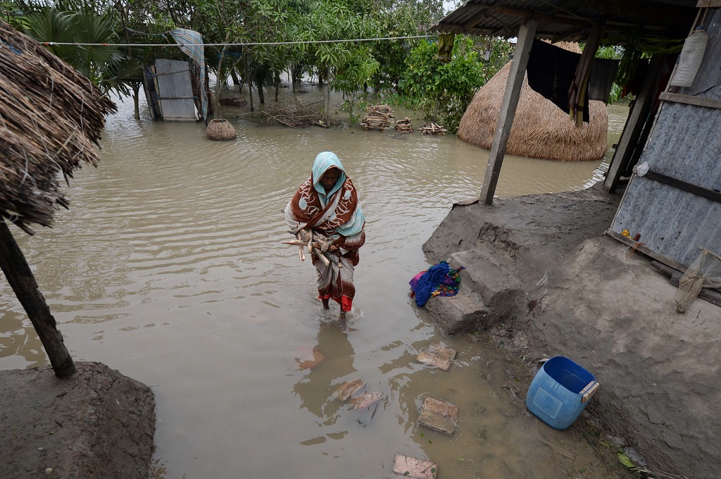 Seorang warga berjalan di tengah genangan air yang dibawa Siklon Bulbul di Koyra, Bangladesh, 10 November 2019. (Foto: AFP/MUNIR UZ ZAMAN)