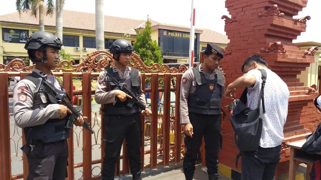 Petugas memeriksa barang bawaan warga yang hendak masuk ke Mapolres Cirebon, Jawa Barat. (Foto: Medcom.id/Rofahan)