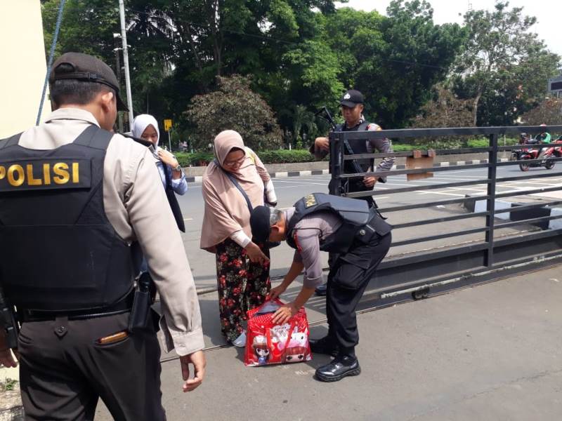 Petugas tengah memeriksa barang bawaan tamubyang masuk Mapolres Metro Depok, Rabu, 13 November 2019. Medcom.id/ Octavianus Dwi Sutrisno