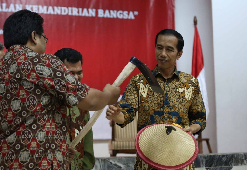 Seorang petani memberikan cangkul kepada Presiden Jokowi. FOTO: MI/RAMDANI